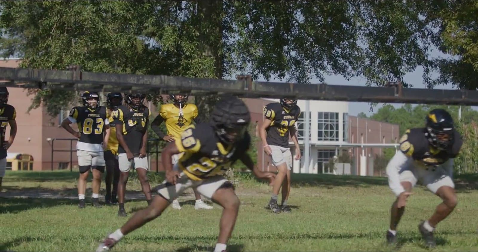 Football players running an explosive start and lateral agility drill at practice